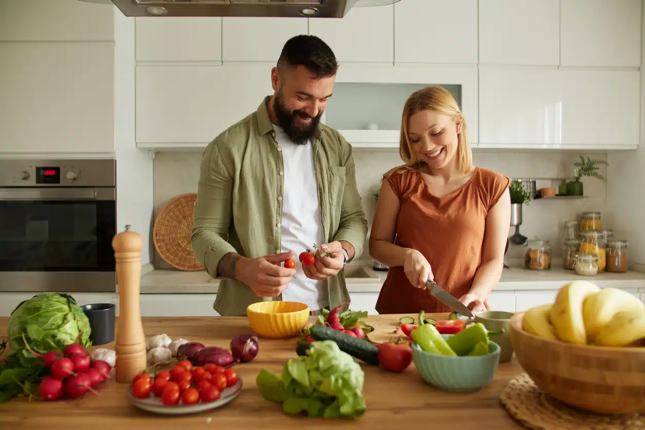 Affectionate couple cutting vegetable in the kitchen